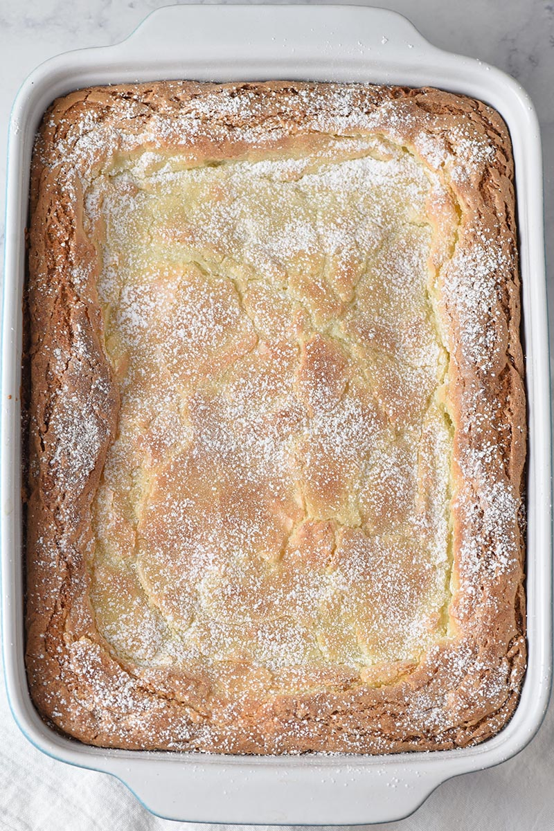 powdered sugar dusted gooey butter cake in baking dish