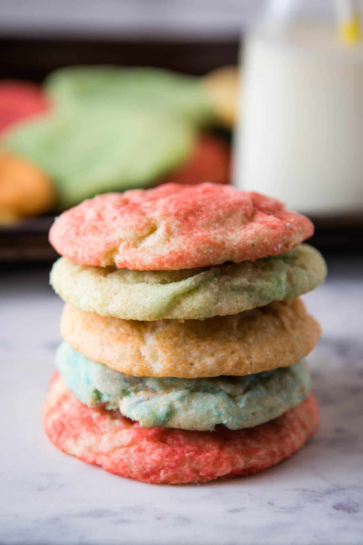 Jello Sugar Cookies on cookie sheet stack of colorful Jello sugar cookies on white marble countertop