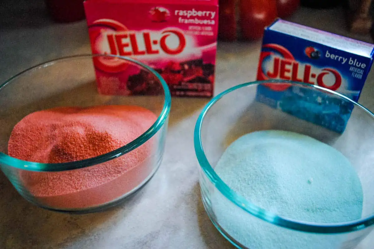 raspberry and berry blue Jello mixes in small bowls for Jello cookies