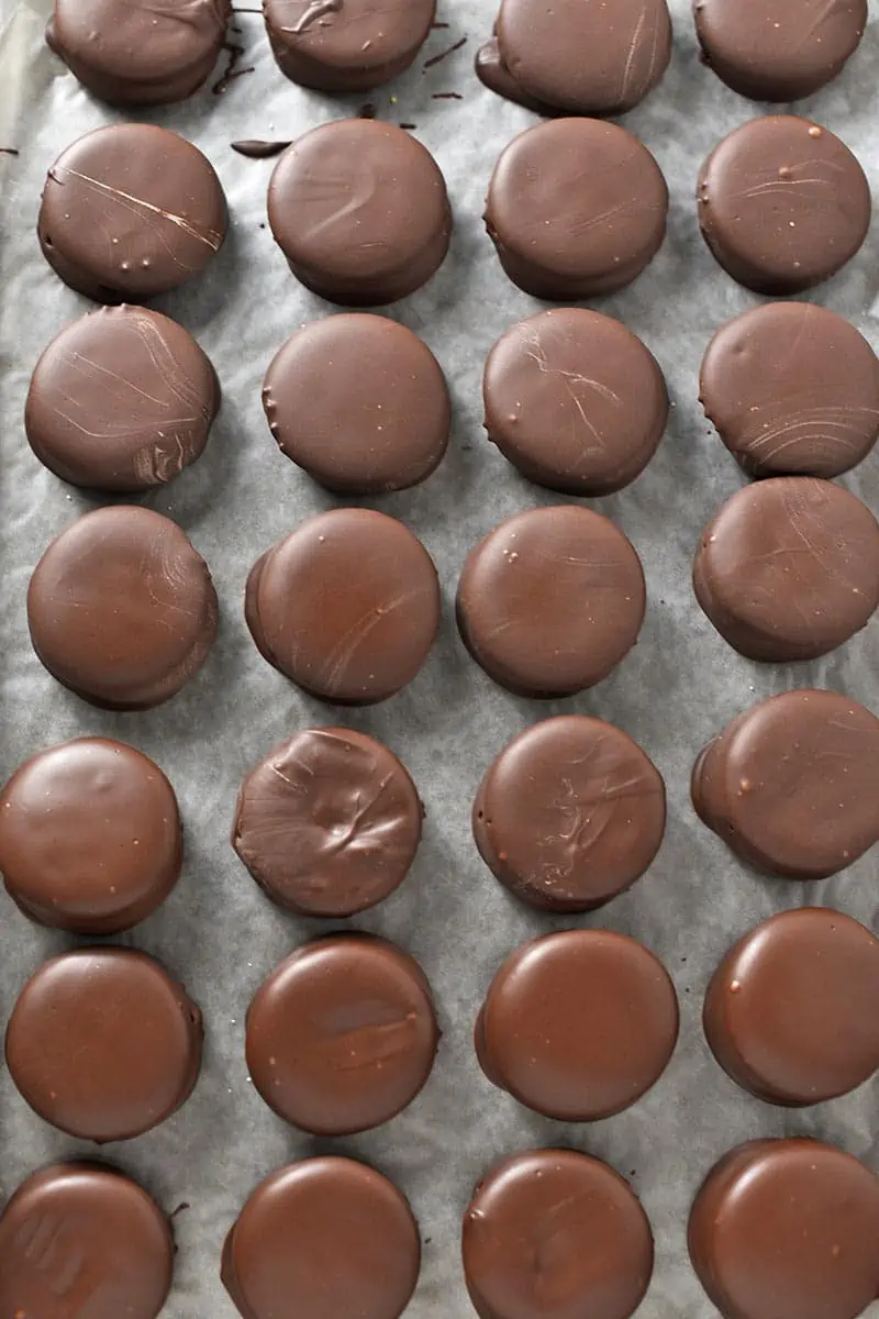 chocolate covered peanut butter crackers, or Ritz cookies, on wax paper covered baking sheet