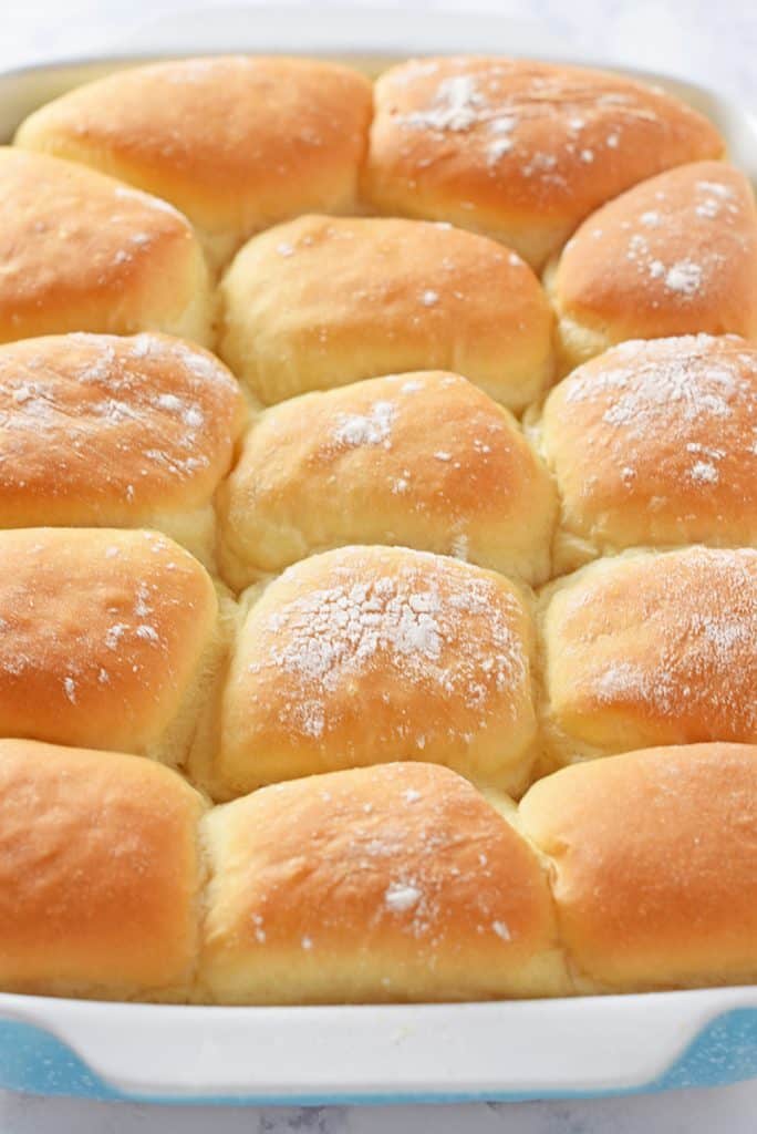 grandma's homemade yeast rolls, pillowy soft, in blue baking dish
