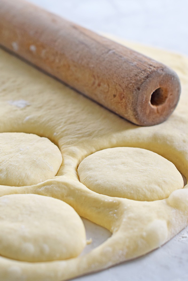 rolling out dough for homemade dinner rolls or yeast rolls with wooden rolling pin