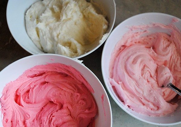 pink and white icing for frosted sugar cookie pops in white bowls