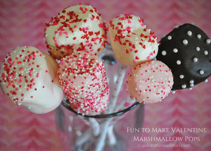 Valentine marshmallow pops in glass cup on pink countertop