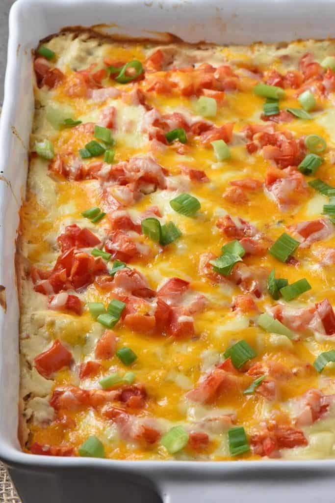 creamy chicken enchiladas with sour cream sauce in white baking dish