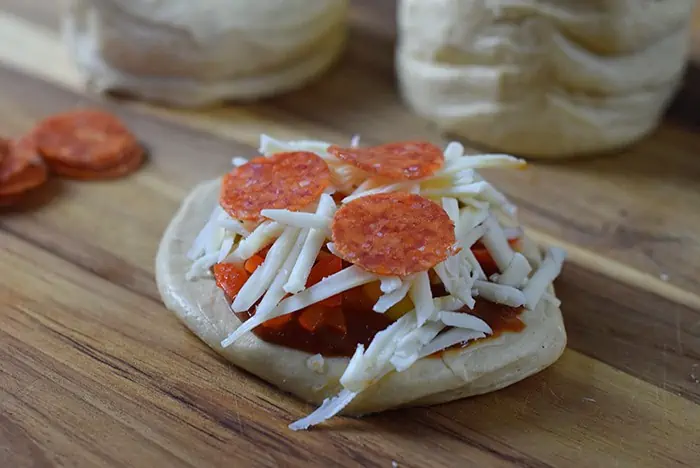 Grands Mini Supreme Pizzas are a quick and easy dinner recipe made with Grands Biscuits, topped with pizza sauce, veggies, pizza cheese, and little mini pepperoni slices.