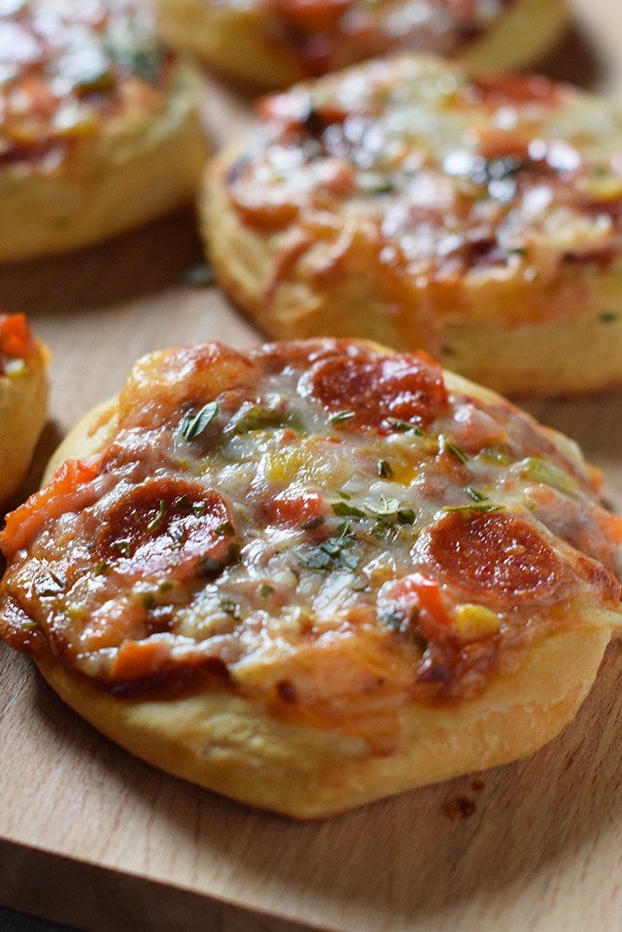 Grands Mini Supreme Pizzas are a quick and easy dinner recipe made with canned biscuits, chopped peppers and tomato, pepperoni, basil, and mozzarella.