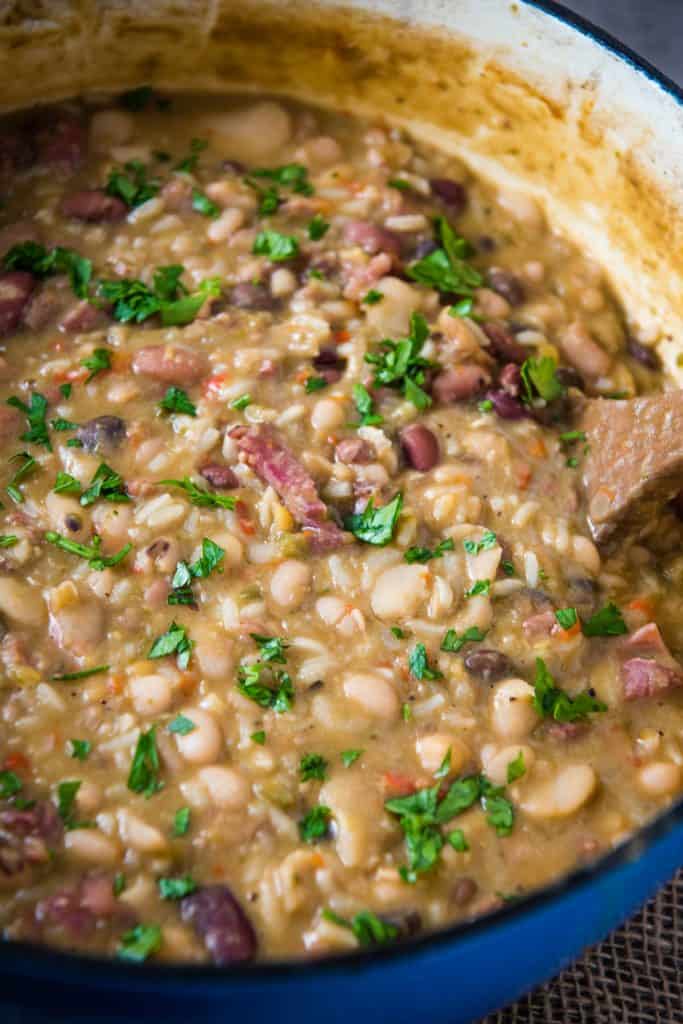 blue Dutch oven full of 15 bean soup with ham