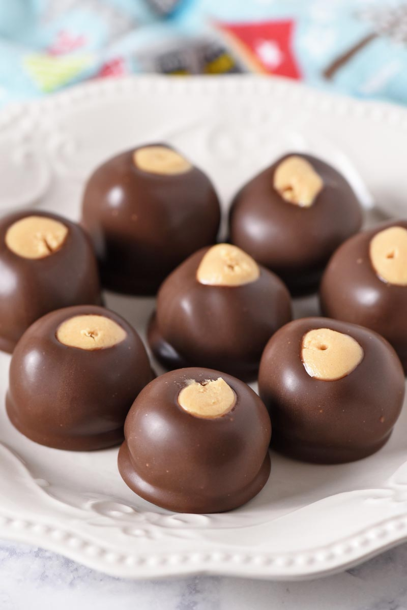 freshly dipped chocolate peanut butter balls, made with a family buckeye balls recipe, on a white ivory plate