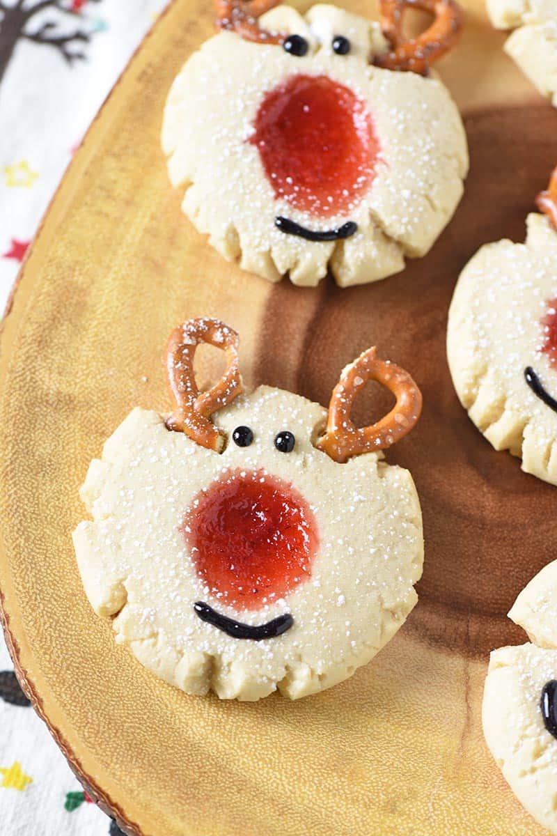 reindeer thumbprint cookies made with mini pretzels and strawberry jam, on log platter