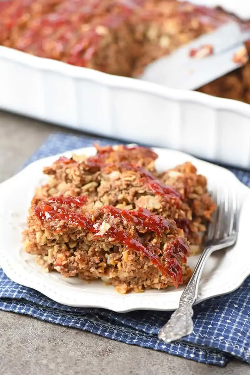 easy meatloaf recipe sliced on a pretty white plate ready to serve with a fork