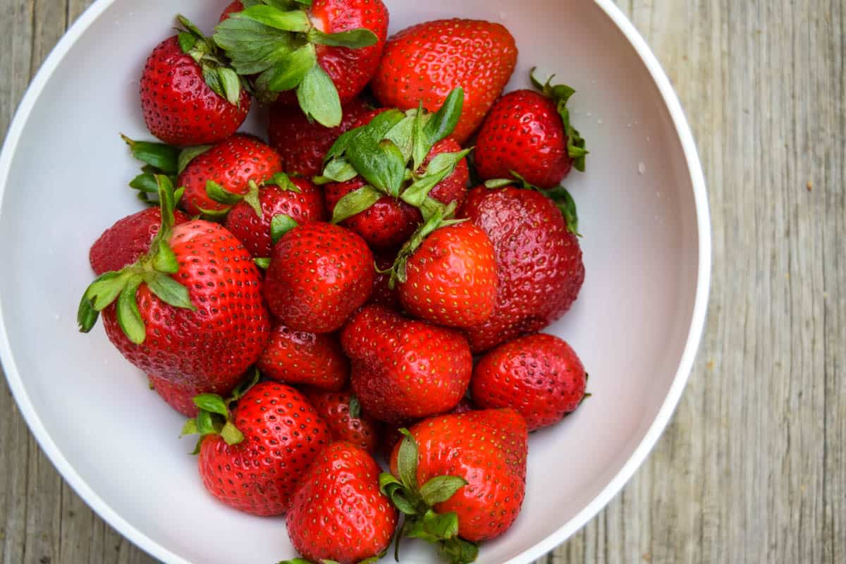 fresh strawberries in white bowl, ready for berry muffins