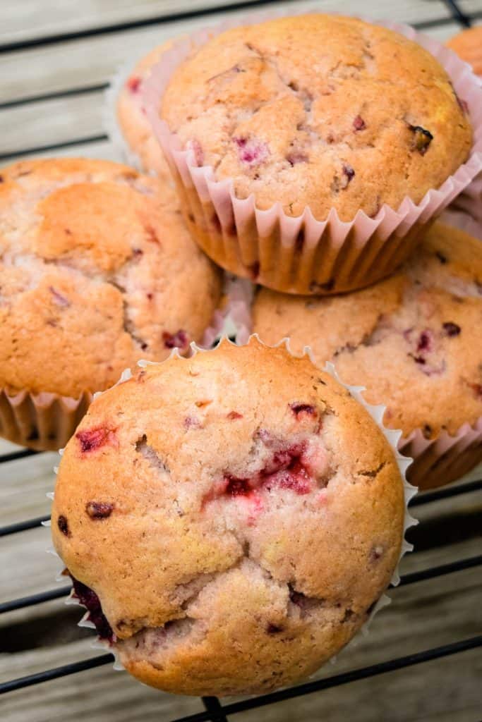pile of strawberry blackberry muffins on wire rack