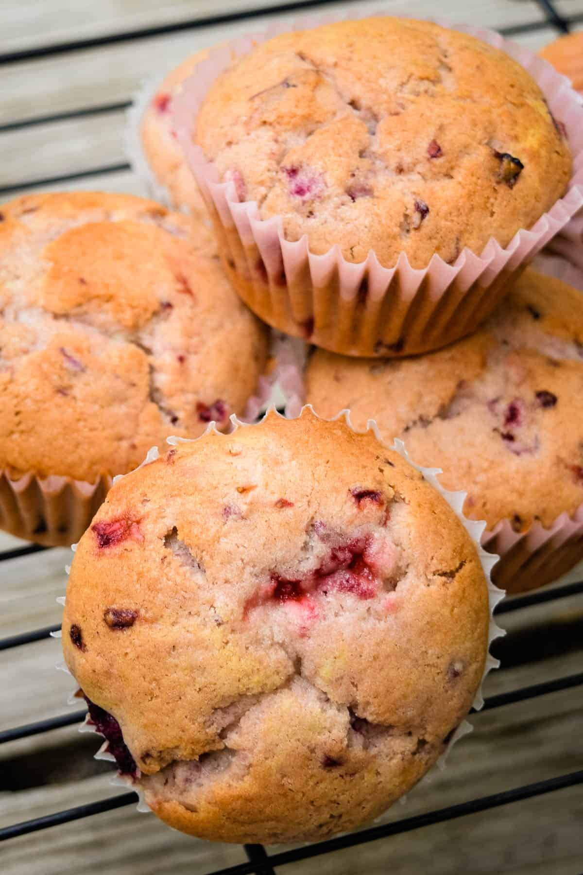 pile of strawberry blackberry muffins on wire rack