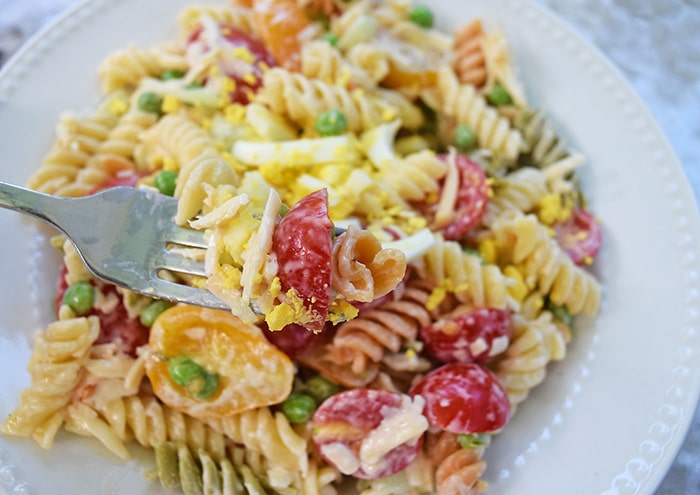 Rotini pasta coated with a lightly creamy dressing, mixed with fresh cucumbers, tomatoes, smoked cheese, and other delicious ingredients. Easy 30 minute pasta salad recipe!