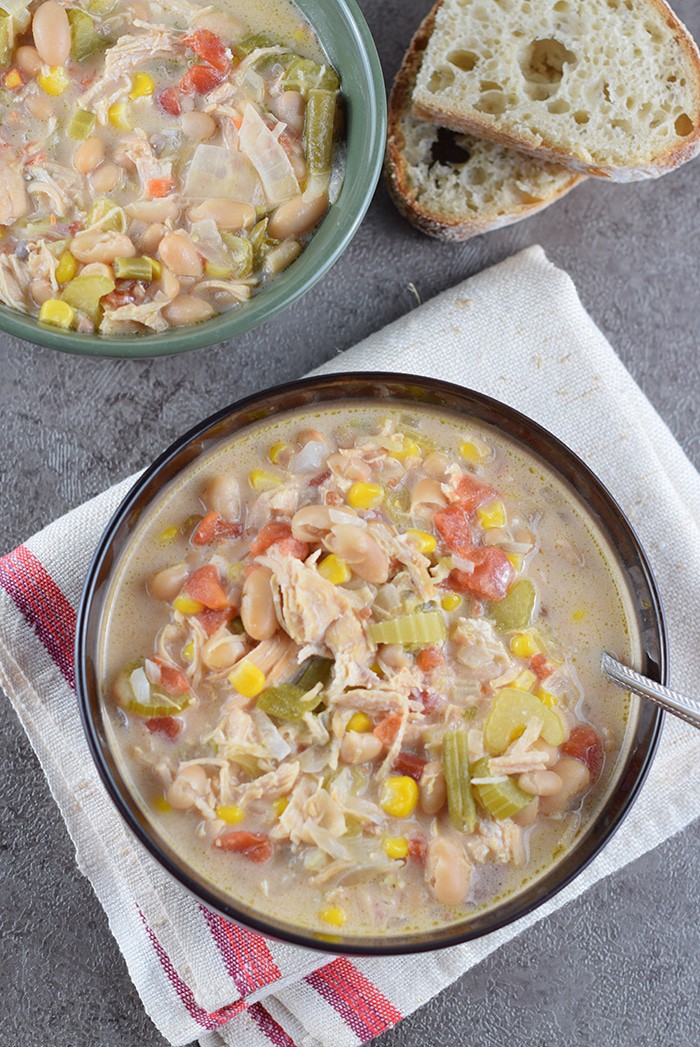 How to make a delicious White Chicken Chili in the slow cooker for an easy family meal. Filled with vegetables, white beans, chicken, green chiles, and cheese.