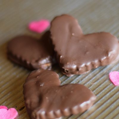 chocolate peanut butter hearts on baking sheet with pink hearts