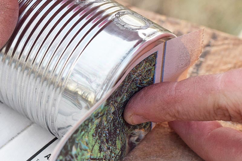 measuring newspaper with a tin can for newspaper seedling pots