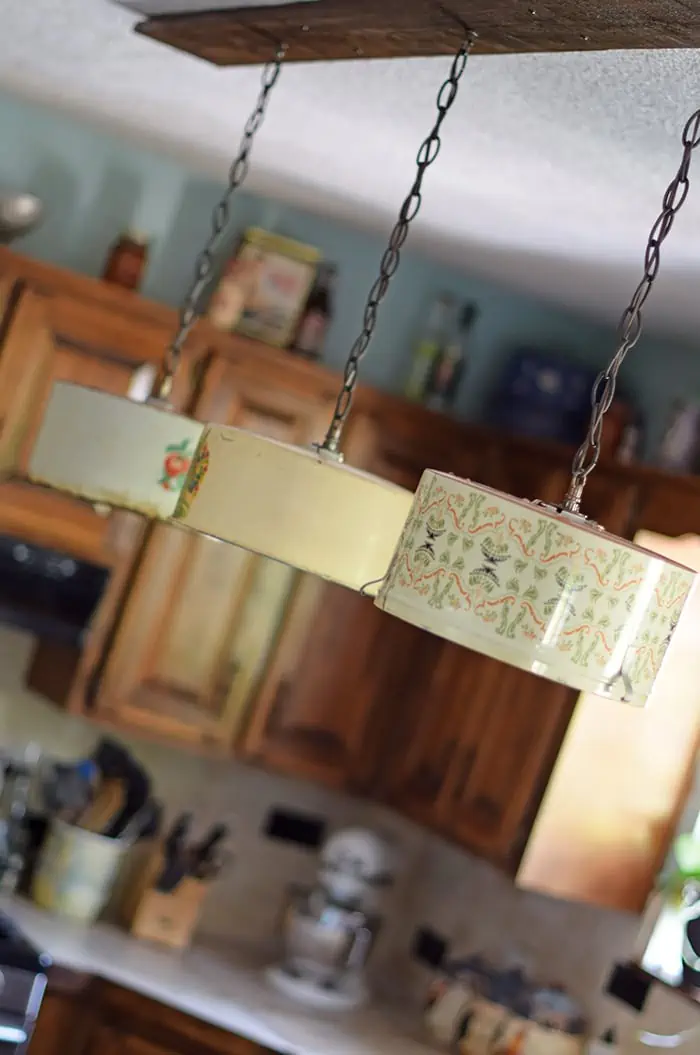 Create a farmhouse kitchen look with DIY light fixtures upcycled from vintage cake tins. How to create a charming look with affordable and simple kitchen lighting.
