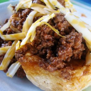 Dutch oven beef and biscuits with shredded cheese on gray plate