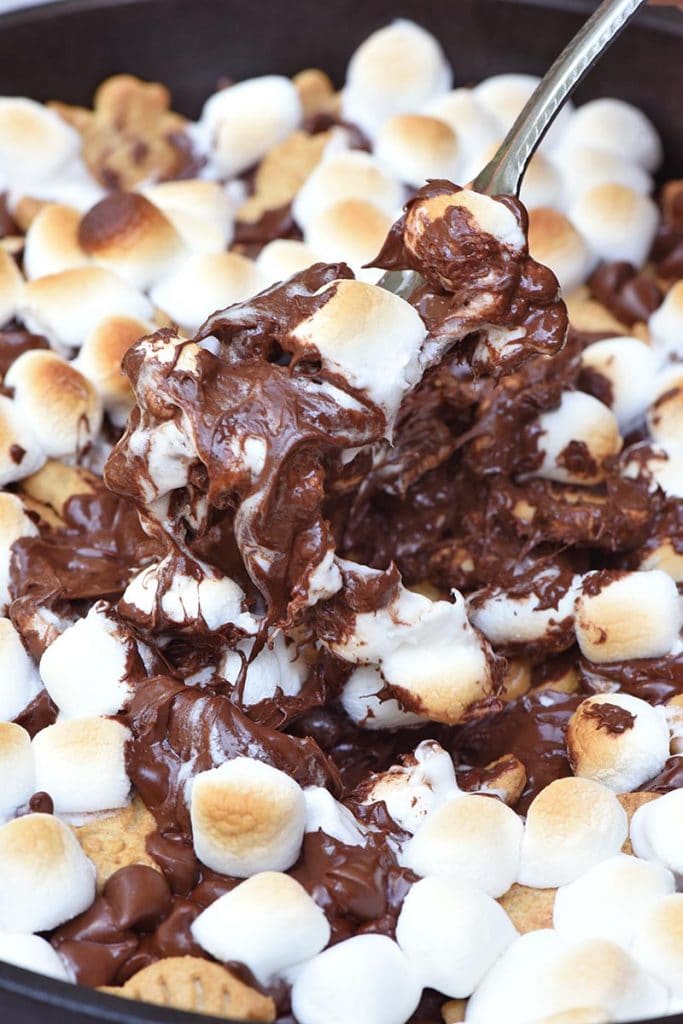 fork with ooey gooey s'mores dip filled with melted chocolate, toasted marshmallows, and graham crackers