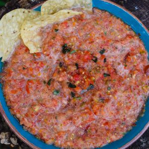 salsa with basil in blue bowl with tortilla chips