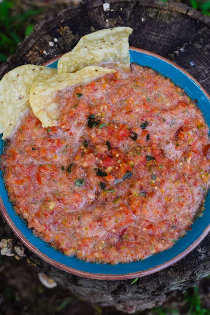 salsa with basil in blue bowl with tortilla chips