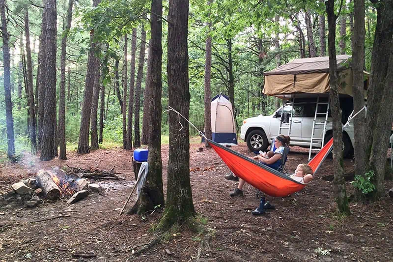 what is dispersed camping, family in Ouachita National Forest dispersed campsite with a rooftop tent, hammock, and campfire