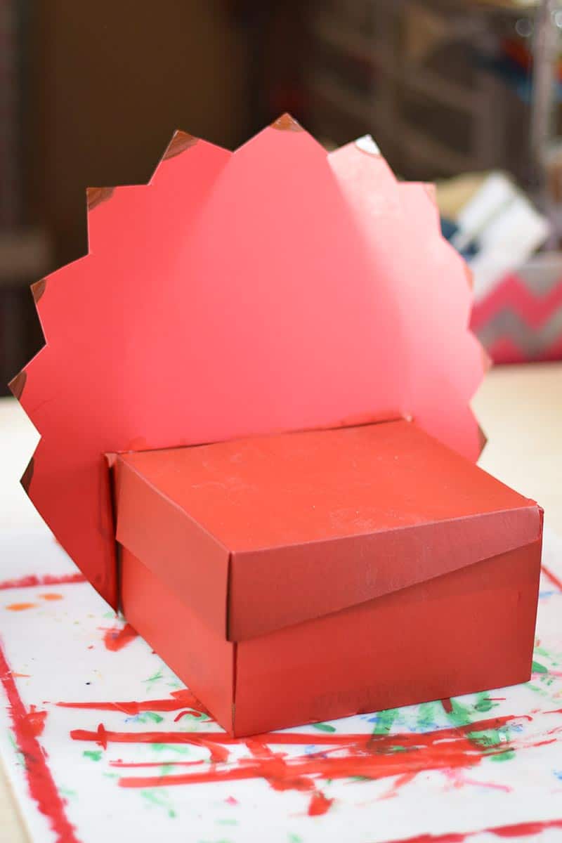 placing triceratops crest  onto shoebox to make a homemade Valentine box