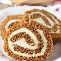 scrumptious pumpkin roll with a cream cheese filling, sliced on an ivory plate
