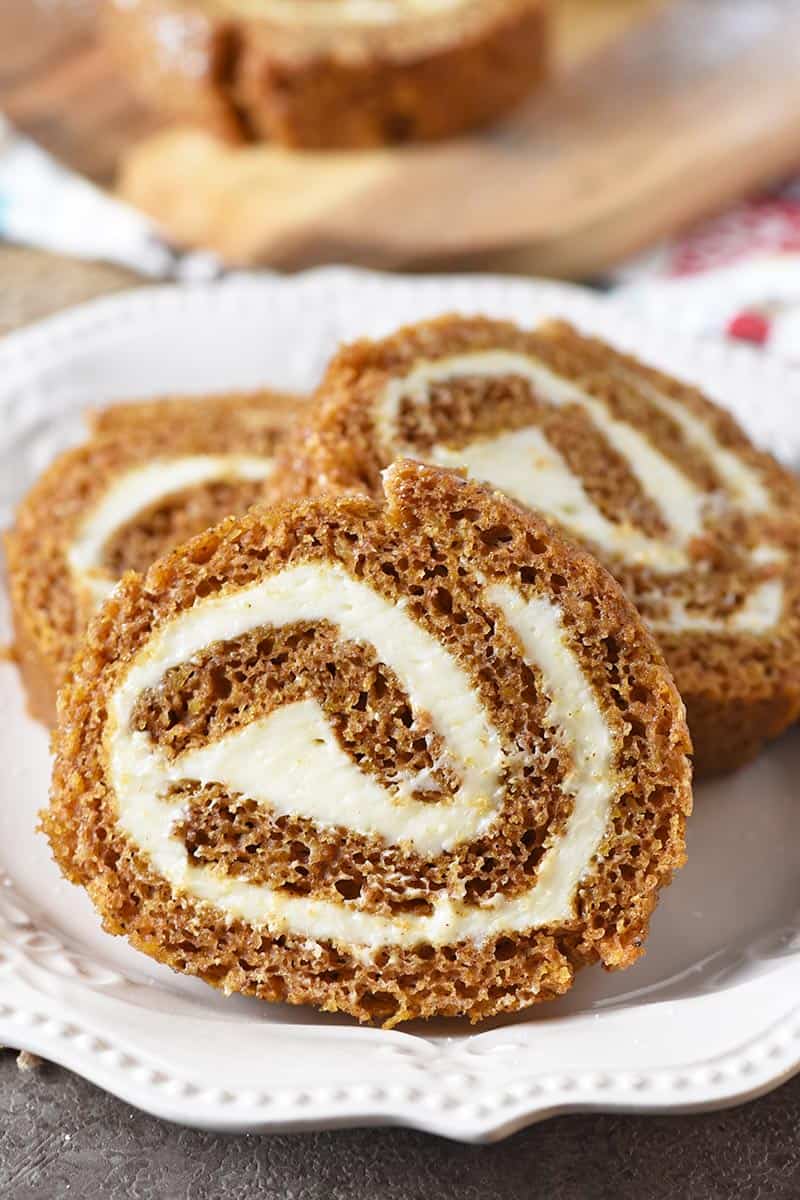 scrumptious pumpkin roll with a cream cheese filling, sliced on an ivory pl...