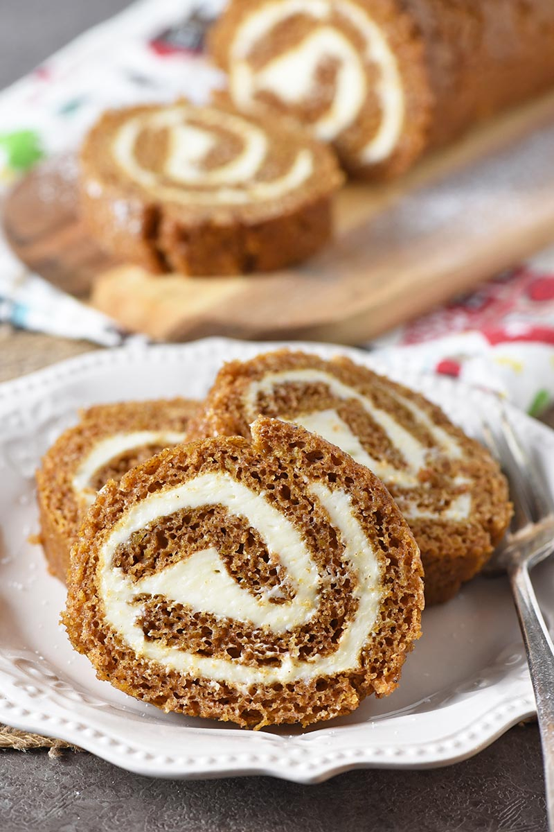 sliced pumpkin roll on an ivory plate for Thanksgiving and Christmas