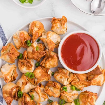 air fryer crab rangoon on white plate with dipping sauce