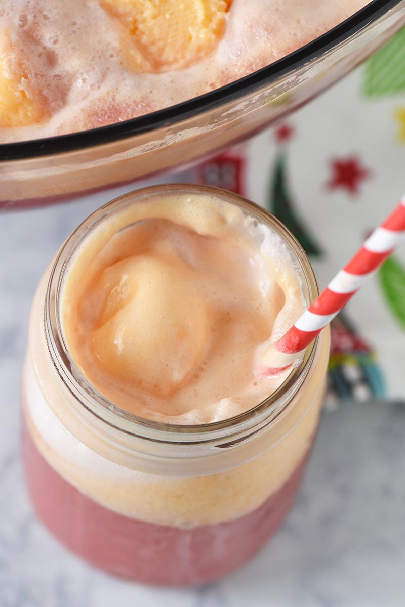 creamy orange sherbet punch in a mason jar with red and white paper straw, easy sherbet punch recipe