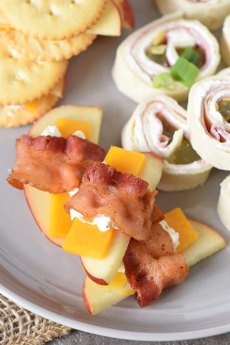 easy bacon appetizers, pinwheels, and cheese and crackers on a gray plate