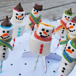 Use marshmallows of all sizes to make yummy Snowman Marshmallow Pops. They're a scrumptious Christmas craft or holiday party idea, and kids love decorating these festive treats.