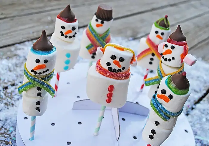 Use marshmallows of all sizes to make yummy Snowman Marshmallow Pops. They're a scrumptious Christmas craft or holiday party idea, and kids love decorating these festive treats. 