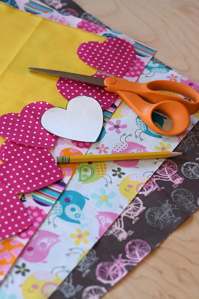 Decorate for Valentine's Day by making a super easy to sew Valentine's Day heart garland with cheap fat quarters from the fabric store. Makes the sweetest Valentine decoration and a fun craft and sewing project! 