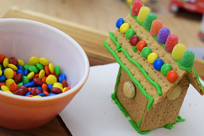 Make a fun and edible kids craft this St. Patrick's Day, a Graham Cracker Leprechaun House. Gather rainbow colored candies, Decorating Icing, and graham crackers, and you're all set!