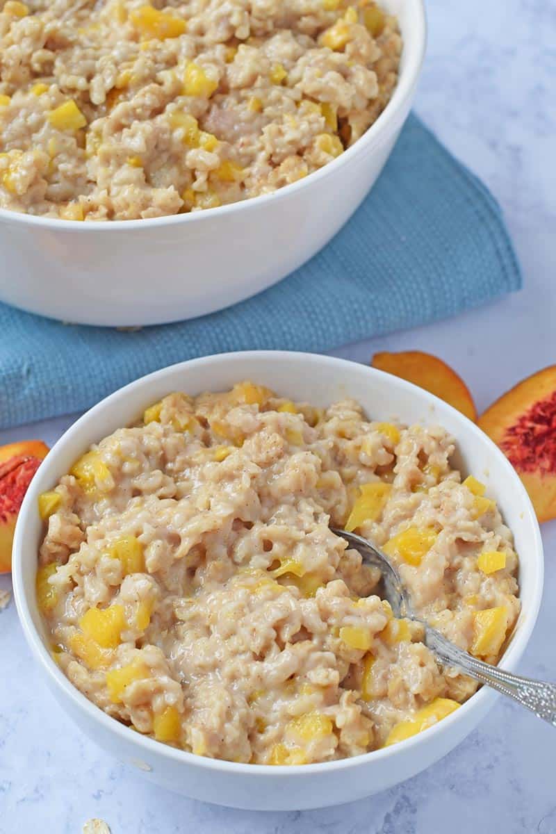 bowl of peaches and cream Instant Pot oatmeal with spoon and fresh peaches