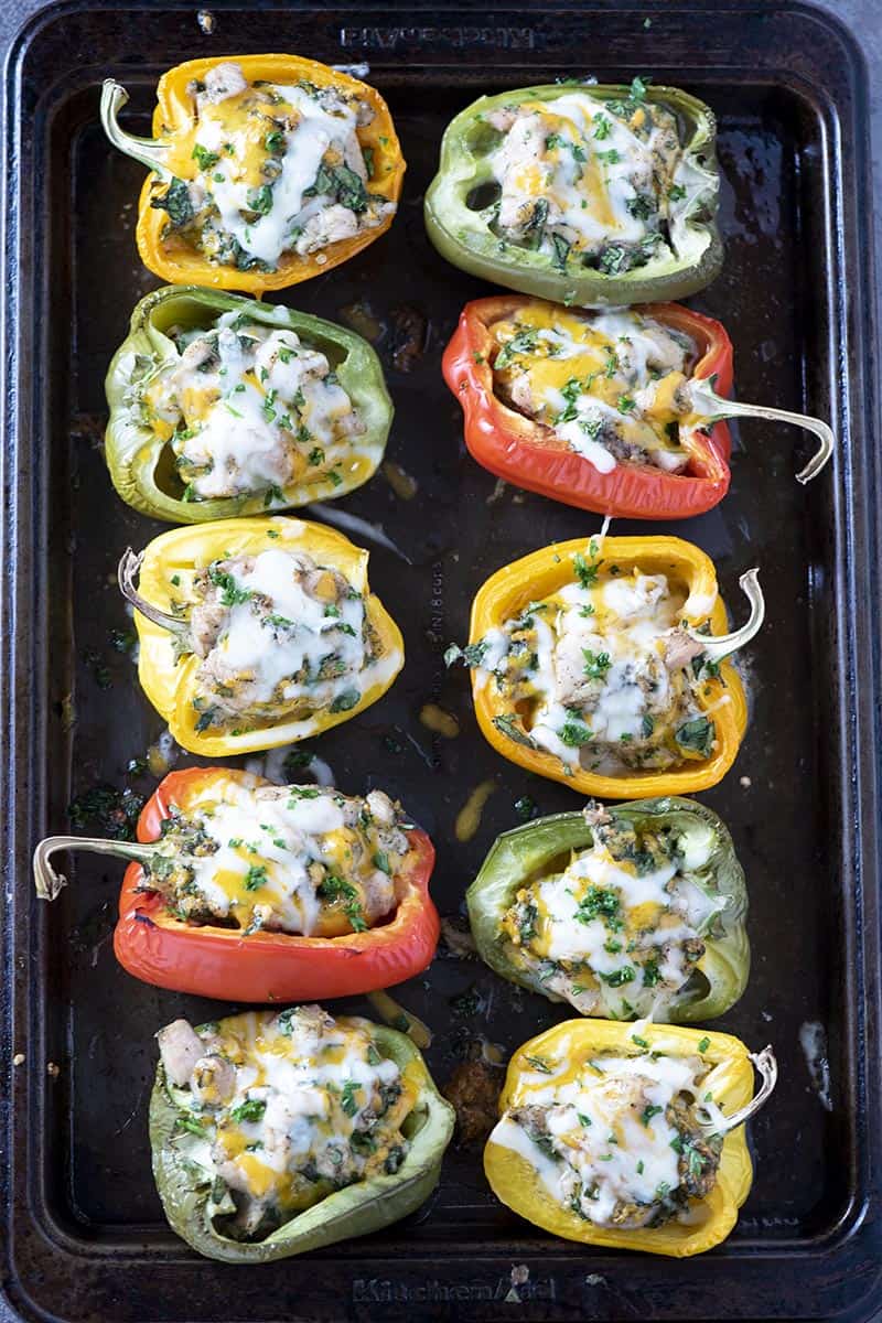 baking sheet with chicken stuffed peppers, melted cheese on top
