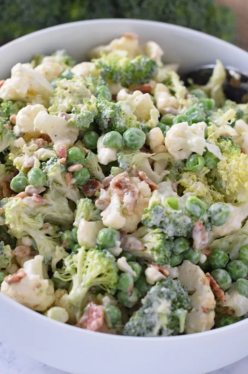 How to make an Easy Broccoli Salad, a delicious side dish recipe for weeknight and holiday meals. Broccoli, cauliflower, bacon, sunflower seeds, and peas.