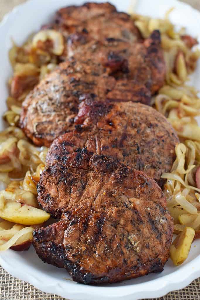 Grill up Maple Pork Chops and top them off with apples and onions for a weeknight meal your family will love. Delicious recipe!