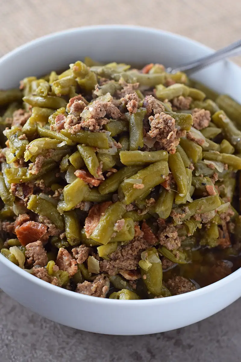 Make Southern Green Beans in the Instant Pot. Pressure cooked to perfection. Bacon, onion, and ground beef give added flavor for a delicious side dish recipe everyone will love!