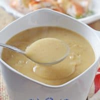 spooning homemade turkey gravy out of a small white gravy bowl