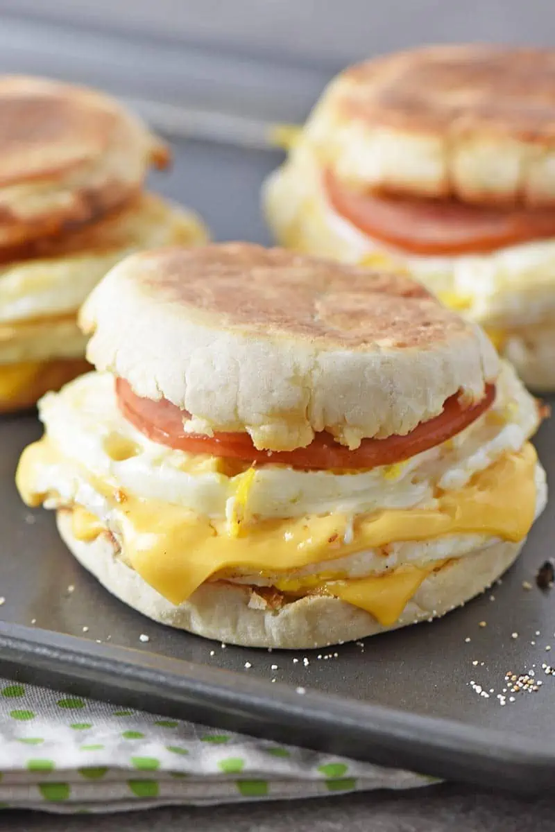 Homemade Egg McMuffin with melted cheese, Canadian bacon, and eggs, on a baking sheet