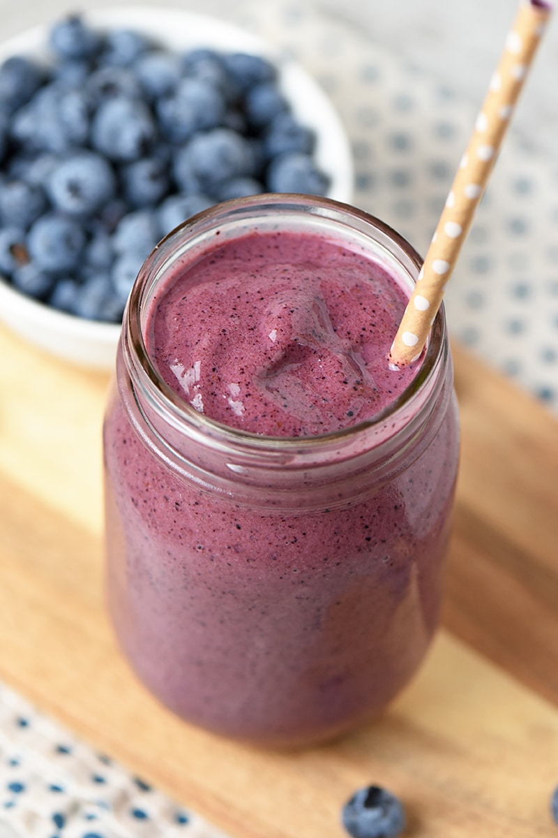 Blueberry Spinach Smoothie in mason jar with straw and fresh blueberries
