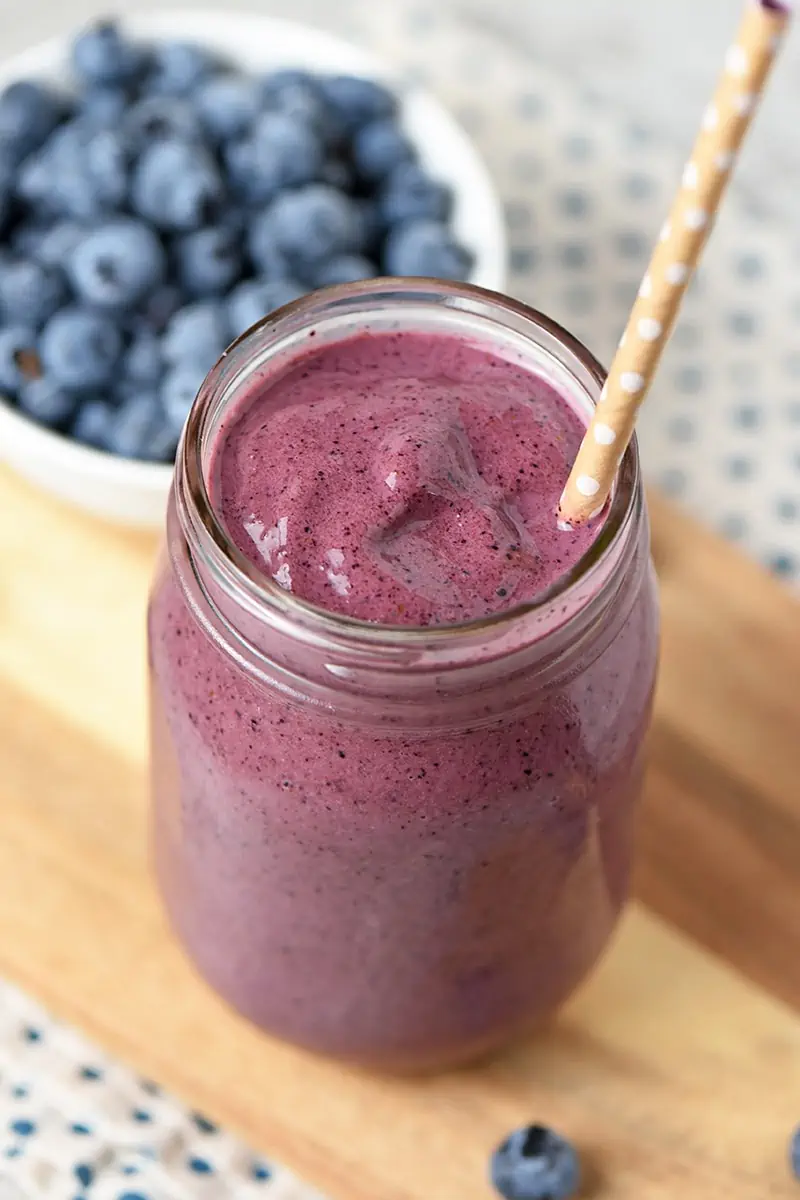 Blueberry Spinach Smoothie in mason jar with straw and fresh blueberries