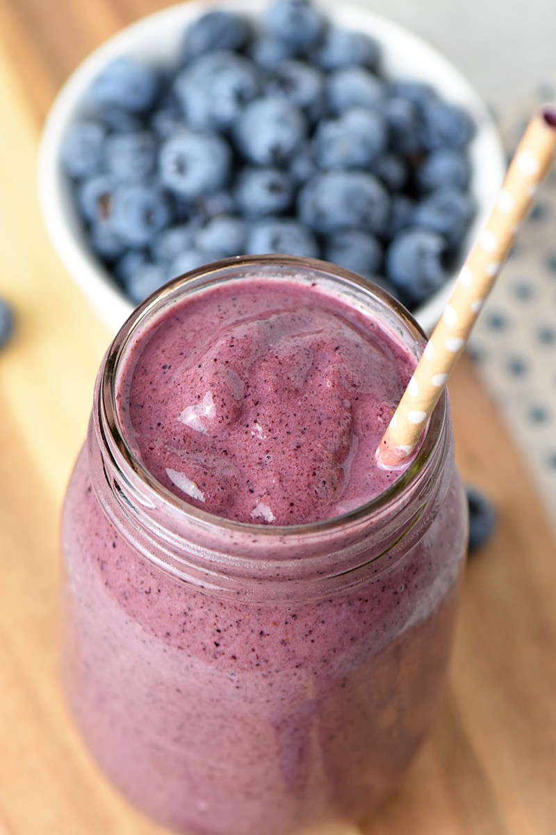 Blueberry Spinach Smoothie in mason jar with polka dot straw and fresh blueberries