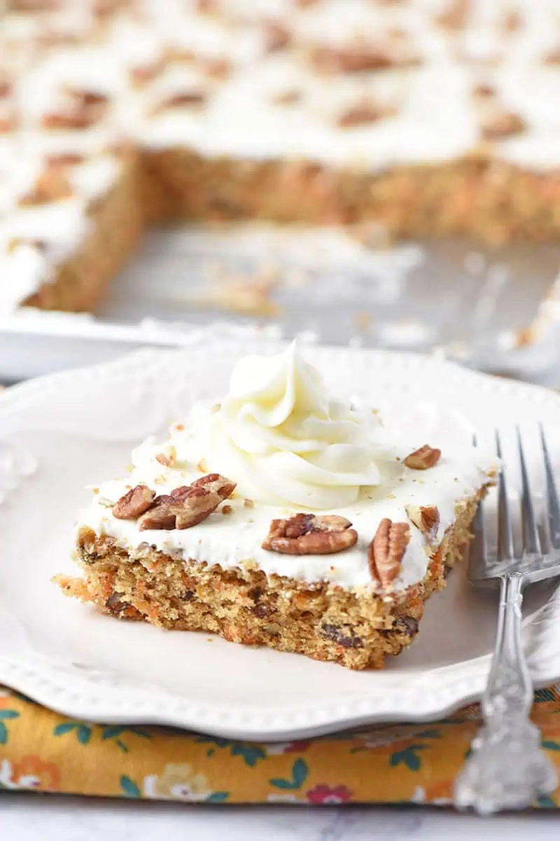 slice of the best ever carrot cake with a swirl of cream cheese frosting on top